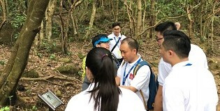 教练在解说香港的郊野特点，同学们都围在一块儿细心聆听。